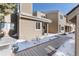 Inviting exterior shows a cozy home with a wooden walkway covered in snow on a sunny day at 6980 Fargo Trl, Littleton, CO 80125