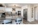 Well-lit kitchen with stainless appliances, gray cabinets, marble countertops, an eat-in bar, and chevron-patterned backsplash at 6980 Fargo Trl, Littleton, CO 80125