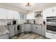 Well-equipped kitchen boasts stainless steel appliances, gray and white cabinets, and modern lighting at 6980 Fargo Trl, Littleton, CO 80125