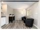 This additional living space features stylish black chairs, modern lighting, wood-look flooring, and a functional dry bar at 6980 Fargo Trl, Littleton, CO 80125