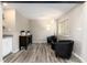 Bright sitting room with two black chairs, a wooden cabinet, and a floor lamp at 6980 Fargo Trl, Littleton, CO 80125