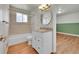 Bathroom with tile backsplash, round mirror, and wood look flooring at 7240 S Cherry Dr, Centennial, CO 80122