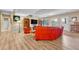 Finished basement with wood floors, a red sofa, a large TV, and natural light from the windows at 10233 Greatwood Ct, Highlands Ranch, CO 80126