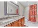 Bathroom featuring double sinks with granite counters, a large mirror, and a shower with a patterned curtain at 10233 Greatwood Ct, Highlands Ranch, CO 80126