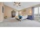 Spacious bedroom with neutral walls, plush carpet, ceiling fan, and bright natural light from the large window at 10233 Greatwood Ct, Highlands Ranch, CO 80126