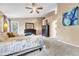 Cozy bedroom with neutral color palette, patterned bedding, ceiling fan, and doorway to another room at 10233 Greatwood Ct, Highlands Ranch, CO 80126