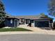 Charming home featuring a 3-car garage, stone accents, blue exterior paint, manicured lawn, and inviting curb appeal at 10233 Greatwood Ct, Highlands Ranch, CO 80126