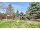 Well-maintained playground set in a spacious backyard offers fun and entertainment for children at 10233 Greatwood Ct, Highlands Ranch, CO 80126