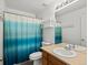 Clean, well-lit bathroom featuring a vanity with sink, toilet, and a shower with a curtain at 386 Monte Vista St, Brighton, CO 80601