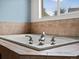 Close up of a soaking tub with stylish fixtures and beautiful tile work at 386 Monte Vista St, Brighton, CO 80601