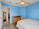 Cozy blue bedroom featuring a bed, dresser, and open doorway showcasing the neutral-toned hallway at 386 Monte Vista St, Brighton, CO 80601