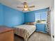 Bright bedroom with blue walls, comfortable bed, ceiling fan, and view from the window at 386 Monte Vista St, Brighton, CO 80601