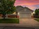 Charming single-Gathering home features a two-car garage, brick accents, a lush lawn, and mature trees at 386 Monte Vista St, Brighton, CO 80601
