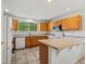 Well-lit kitchen featuring tile flooring, oak cabinets, and a breakfast bar with a tile countertop at 386 Monte Vista St, Brighton, CO 80601