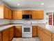 Bright kitchen featuring wooden cabinetry, tile countertops, and modern appliances for a functional cooking space at 386 Monte Vista St, Brighton, CO 80601