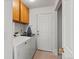 Bright laundry room featuring a washer, dryer, cabinets, and storage at 386 Monte Vista St, Brighton, CO 80601