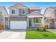 Two-story house with gray siding, white garage door, and landscaped lawn at 15963 Syracuse St, Thornton, CO 80602