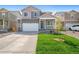 Two-story house with gray siding, white garage door, and landscaped lawn at 15963 Syracuse St, Thornton, CO 80602