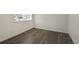 Empty spare bedroom with dark gray vinyl plank flooring and a window at 15963 Syracuse St, Thornton, CO 80602