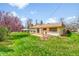 Well-maintained backyard with green grass, patio, and mature blossoming tree at 8204 S Cody St, Littleton, CO 80128