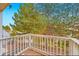 Relaxing balcony offering a green view with white railings and a wooden floor under a big tree at 4038 S Richfield Way, Aurora, CO 80013