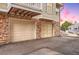 Two-car garage featuring a sturdy brick facade and ample parking space, adding to the townhome's functionality and aesthetic appeal at 4038 S Richfield Way, Aurora, CO 80013