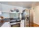 Well-equipped kitchen featuring stainless steel refrigerator, range hood, and modern appliances, designed for culinary enthusiasts at 4038 S Richfield Way, Aurora, CO 80013