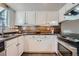 Efficient kitchen featuring ample counter space, mosaic backsplash, modern appliances, and bright cabinetry at 4038 S Richfield Way, Aurora, CO 80013