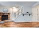 Living room featuring a brick fireplace, hardwood floors, and access to the staircase at 4038 S Richfield Way, Aurora, CO 80013