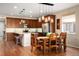 Open concept kitchen with stainless appliances and wooden dining table at 18067 E Anthem Dr, Parker, CO 80134