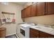 Well-organized laundry room featuring modern washer and dryer, sink, and ample cabinet space at 18067 E Anthem Dr, Parker, CO 80134