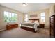 Comfortable main bedroom featuring large windows for natural light, complementing the neutral color scheme and wooden furnishings at 18067 E Anthem Dr, Parker, CO 80134