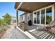 Relaxing covered patio with stone fire pit, chaise lounge, and sliding glass doors for seamless indoor/outdoor living at 18067 E Anthem Dr, Parker, CO 80134