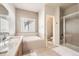 Well-lit bathroom featuring a soaking tub, standalone shower, and tile flooring at 16534 E Fire Fly Ave, Parker, CO 80134