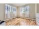 Light-filled bedroom with wood floors, and soft, light-filtering curtains on two windows at 16534 E Fire Fly Ave, Parker, CO 80134