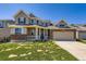 Charming two-story home with a welcoming porch and a well-maintained lawn on a sunny day at 16534 E Fire Fly Ave, Parker, CO 80134