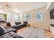 Bright living room with a large sectional sofa, a patterned rug, and several windows for natural light at 16534 E Fire Fly Ave, Parker, CO 80134