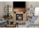 Close-up of a stone fireplace with a wooden mantle and a lit fire at 15218 W La Salle Ave, Lakewood, CO 80228
