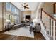 Elegant living room featuring a stone fireplace, hardwood floors, and large windows at 15218 W La Salle Ave, Lakewood, CO 80228