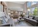 Spacious living room with a brick wall detail, staircase, and views into the kitchen at 15218 W La Salle Ave, Lakewood, CO 80228