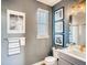 Clean bathroom with gray walls, white vanity, and framed astronaut prints at 4616 Girardot Pt, Castle Rock, CO 80104