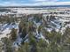 Breathtaking aerial perspective of a home surrounded by vast, snow-covered landscapes and towering trees at 9142 Warriors Mark Dr, Franktown, CO 80116