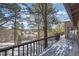 Wooden deck with railings offers stunning views of the surrounding snow-covered landscape and tall pine trees at 9142 Warriors Mark Dr, Franktown, CO 80116