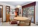 Charming dining area with wooden furniture, a decorative bookcase, and sliding glass doors to an outdoor balcony at 9142 Warriors Mark Dr, Franktown, CO 80116