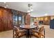 Open floor plan dining area with wood paneling, a stone accent wall, and natural light at 9142 Warriors Mark Dr, Franktown, CO 80116