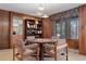 Elegant dining room boasts classic wood paneling and natural light at 9142 Warriors Mark Dr, Franktown, CO 80116