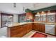 Bright kitchen with wooden cabinetry, granite countertops, and a sunny dining area with an outside view at 9142 Warriors Mark Dr, Franktown, CO 80116