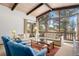 Bright living room with a vaulted wood ceiling, large windows and a comfortable seating area with lovely forest views at 9142 Warriors Mark Dr, Franktown, CO 80116