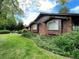 Close up of a single story home with brick and wood exterior and a green lawn at 12075 W 18Th Dr, Lakewood, CO 80215