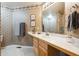 Traditional bathroom with patterned wallpaper, wooden vanity, and framed artwork, offering a classic and inviting space at 13560 Detroit St, Thornton, CO 80241